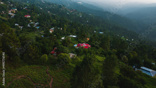 Aerial view of beautiful homes in green hills surrounded by trees 