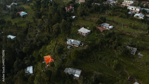 Aerial view of beautiful homes in green hills surrounded by trees 
