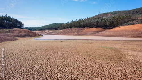 Fototapeta Naklejka Na Ścianę i Meble -  Landscape of low water and dry land in advance, severe drought in the reservoir of Portugal. Ecological disaster, soil dehydration. desert, drought,