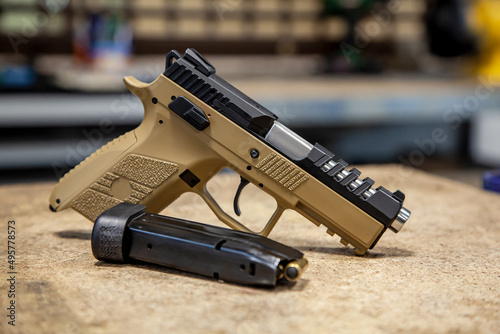 Modern traumatic pistol. Non-lethal short-barreled weapon for self-defense. Light back. photo