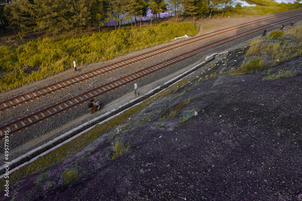 The railroad tracks pass through the forest track. Photo taken from the side of a high cliff