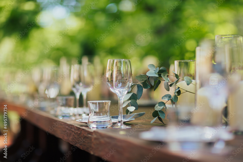 Wedding table decoration with flowers and candles on wooden tables. Wedding in rustic style outdoor.