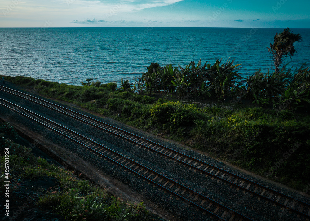 The railroad tracks pass through forest trails, between sea views and cliffs that make it beautiful. Stunning railroad concept. The railroad tracks pass through forest trails, between sea views and cliffs that make it beautiful. Stunning railroad concept.
