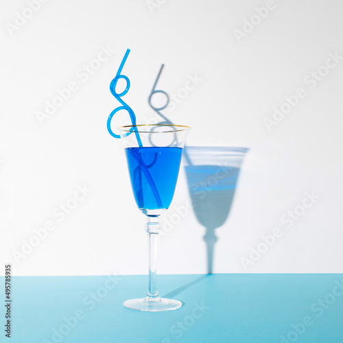 Tasty Blue Lagoon cocktail on pastel blue and white background. Summer, beach or nightlife concept.