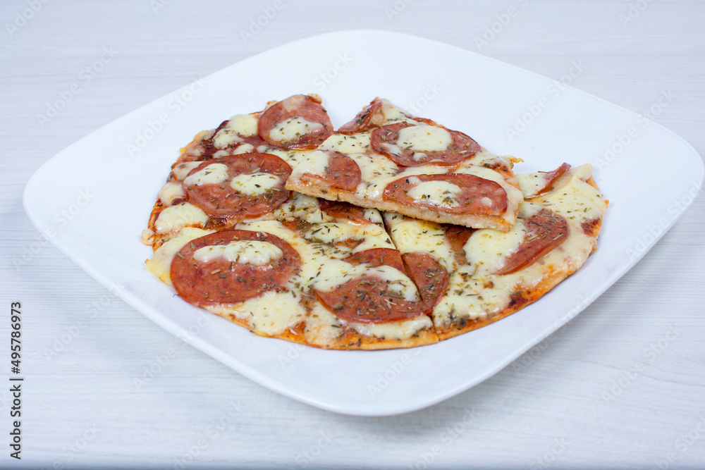 Traditional tomato, cheese, oregano pizza on red checkered napkin