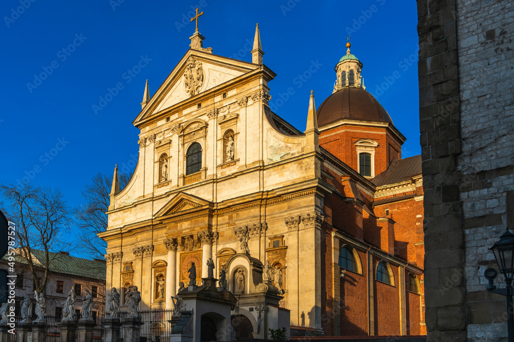 Fototapeta premium Church of Saints Peter and Paul in Krakow at sunset in the rays of the evening sun against the blue sky in spring, side view