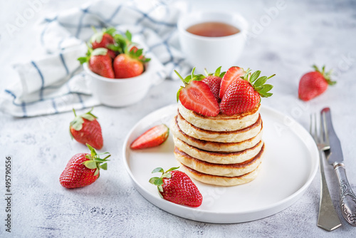 Pancakes decorated with strawberries in a plate