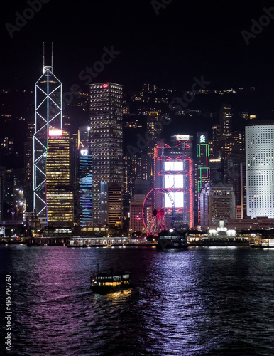 Vertical shot of illuminated downtown buildings at night in the Tsim Sha Tsui district of Hong Kong photo