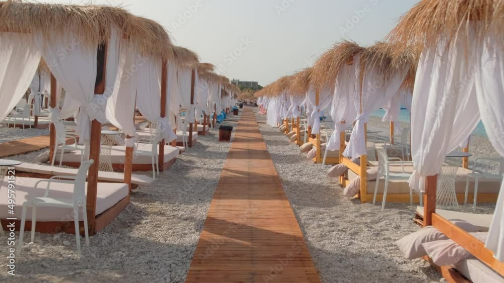 Canopy beach bed with white curtains on an empty beach in summer