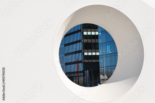 Circle window looking into the street at odern architecture photo