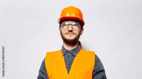 Studio portrait of young smiling construction worker on white. Looking up.