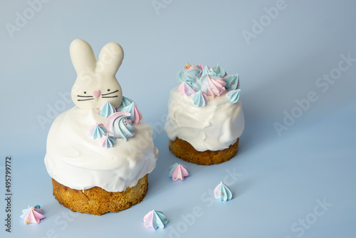 Easter cake and colorful eggs and Easter decorative bunny on a blue background with spring cherry blossoms and copy space. Easter Ukraine orthodox sweet bread.Easter card concept