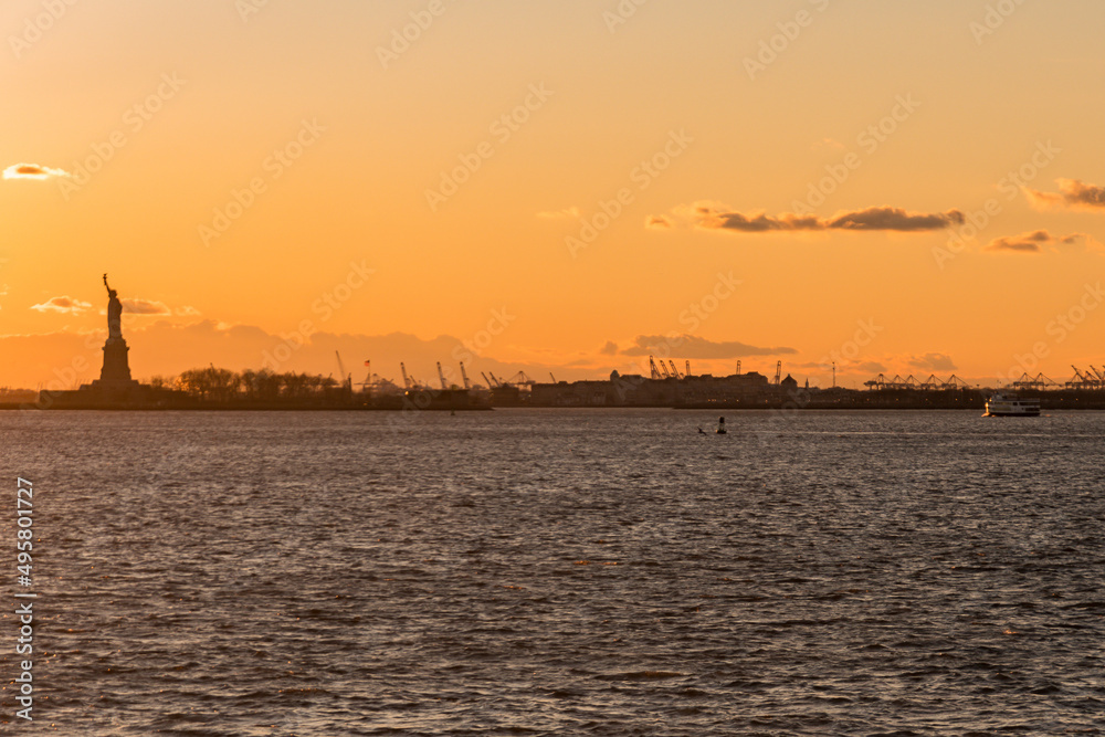 That Statue of Liberty and the cranes of the Port of Newark at sunset