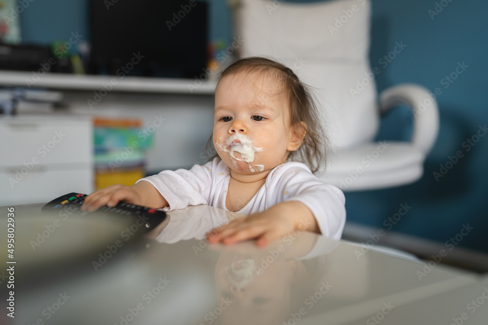 One baby nasty small caucasian child little girl with food around her mouth and on dirty face making mess at home childhood and growing up concept copy space One baby nasty small caucasian child little girl with food around her mouth and on dirty face making mess at home childhood and growing up concept copy space