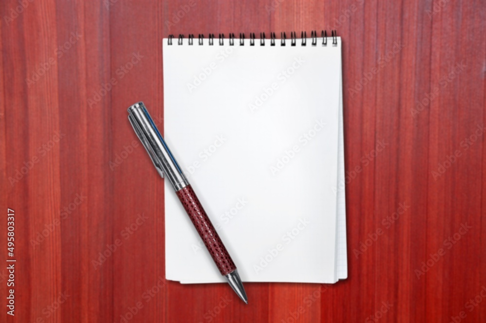 Notepad for writing text with pen on a red background. Notepad for writing text with pen on a red background.