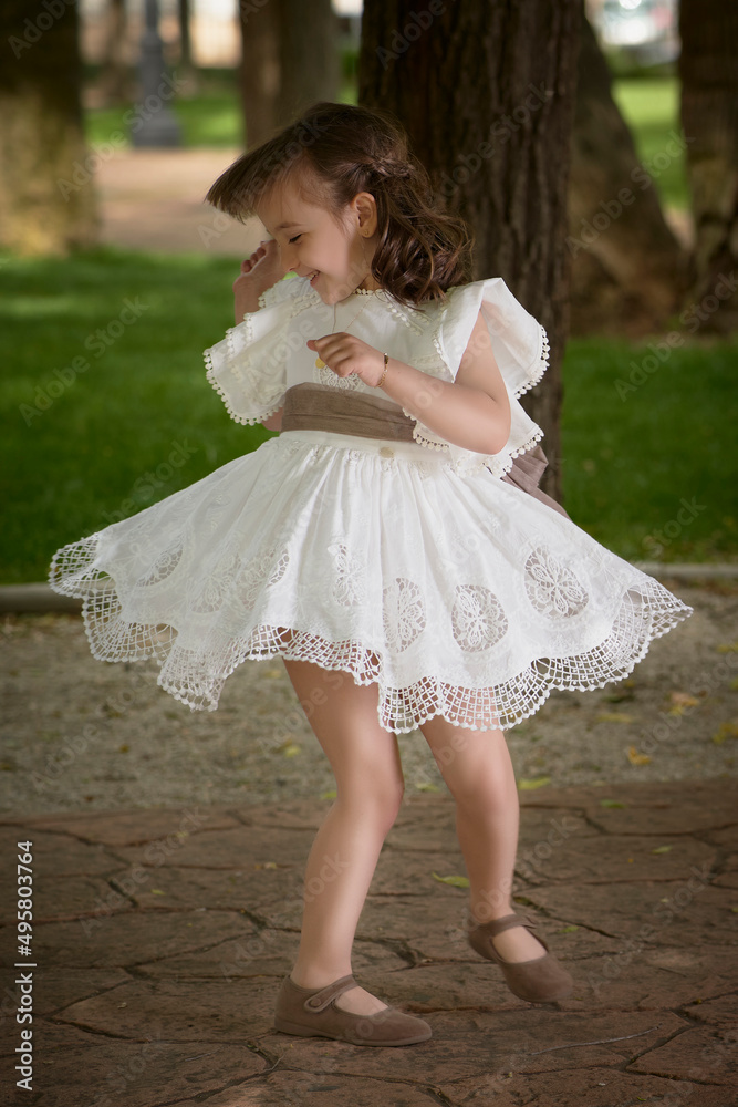 Communion girl dancing in a park