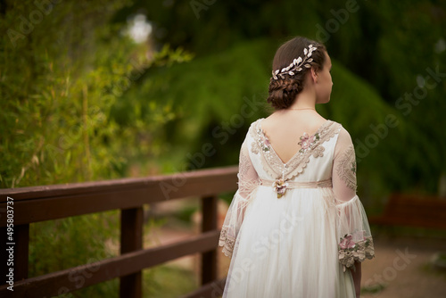 Communion girl posing with her back turned in a park photo