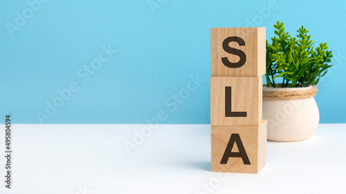 sla - word from wooden blocks with letters, blue background. copy space available photo