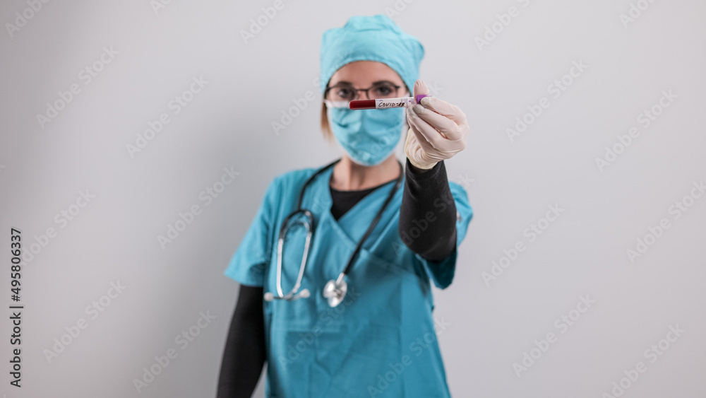 Female doctor examines a blood sample for the Corona virus - studio photography Female doctor examines a blood sample for the Corona virus - studio photography
