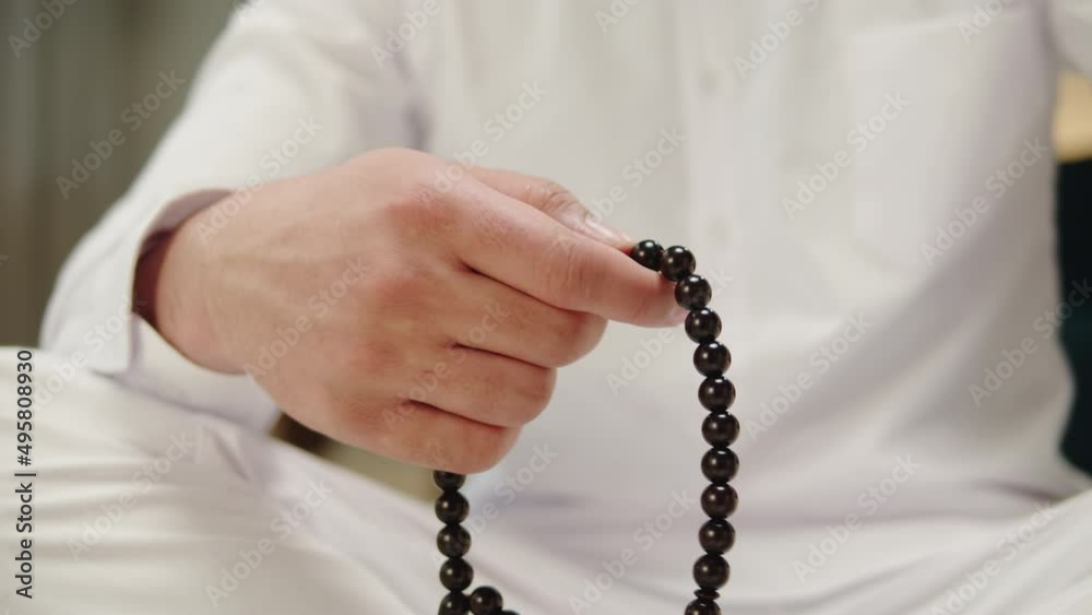 Man praying with rosary beads close-up, islamic religion. Religious holiday Ramadan, holy month. Muslim worship, male person making traditional prayer to God. Man praying with rosary beads close-up, islamic religion. Religious holiday Ramadan, holy month. Muslim worship, male person making traditional prayer to God.