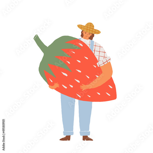 Farmer woman in a straw hat holding a huge fresh strawberry. Eat local, organic and healthy eating and veganism concept.