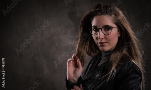 Close-up of a young attractive woman against dark grey background - studio photography