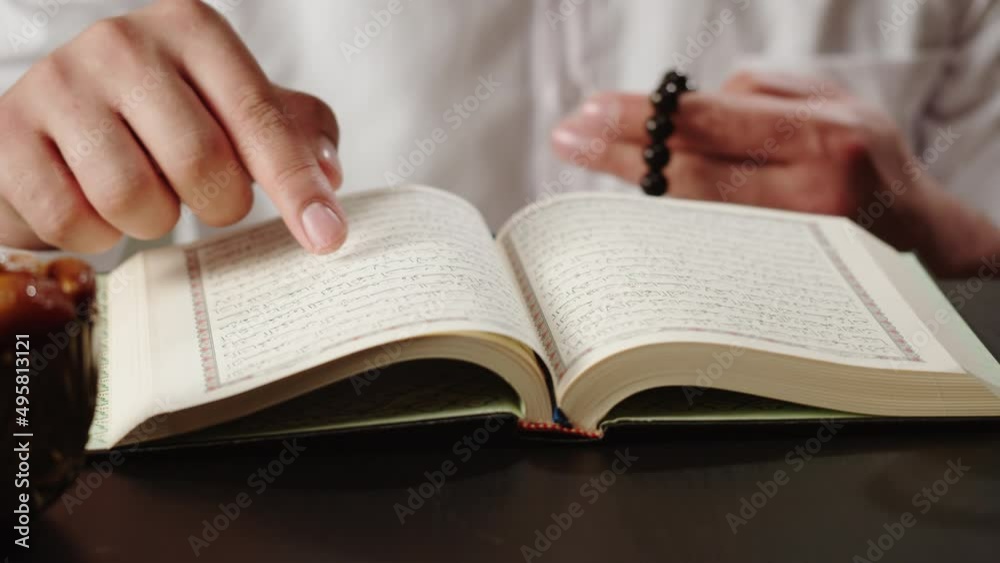 Man praying with rosary, reading Koran close-up, islamic religion. Religious holiday Ramadan, holy month. Muslim worship, male person making traditional prayer to God.