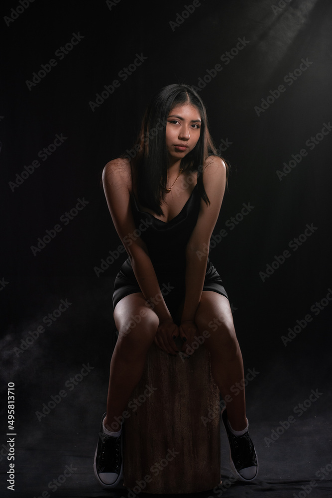 Fototapeta premium portrait of latina girl in studio isolated on black background, concept of portrait session.