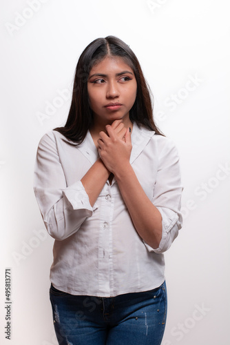 frontal portrait of Hispanic girl in studio isolated on black background with white shirt, alternative modeling concept.