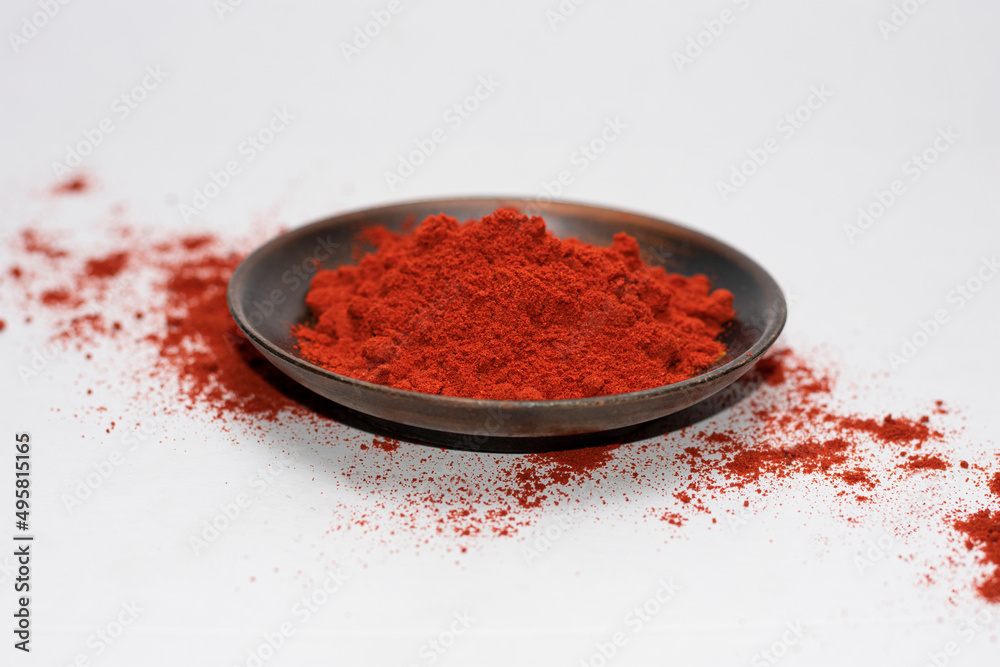 paprika seasoning in a wooden bowl on a white background where you can also see scattered paprika paprika seasoning in a wooden bowl on a white background where you can also see scattered paprika