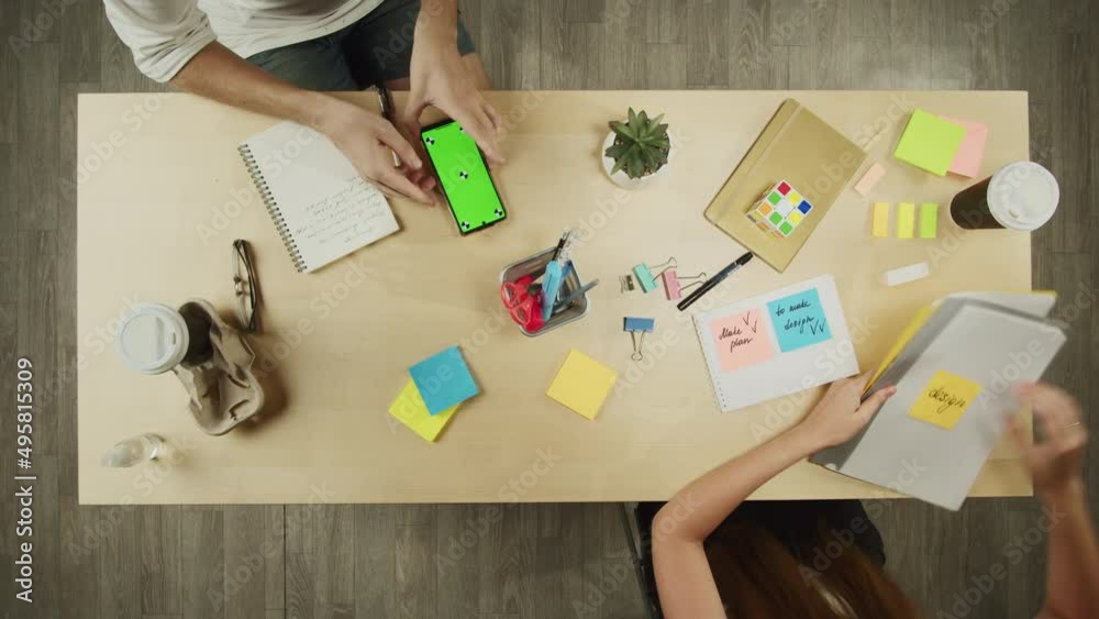 Business people working in modern office together top view. Creative workers discussing tasks. Project planning, group brainstorming. Team leader giving files, using phone with chroma green screen. 