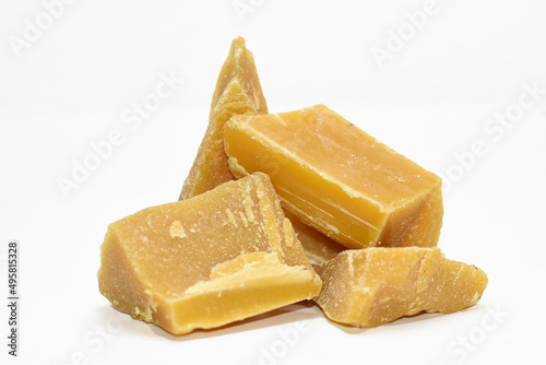 blocks of virgin beeswax stacked on a white background