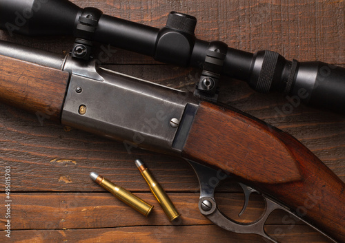 Lever-action hunting rifle and bullets on wood