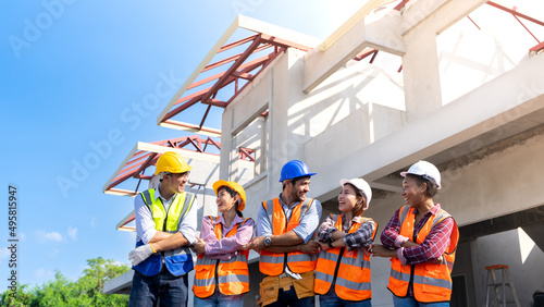 A group of multi-ethnic engineers shake hands at a under construction site smiling happy to work together.The project was successful.Cooperation, collaborations of construction workers.Auld Lang Syne. photo