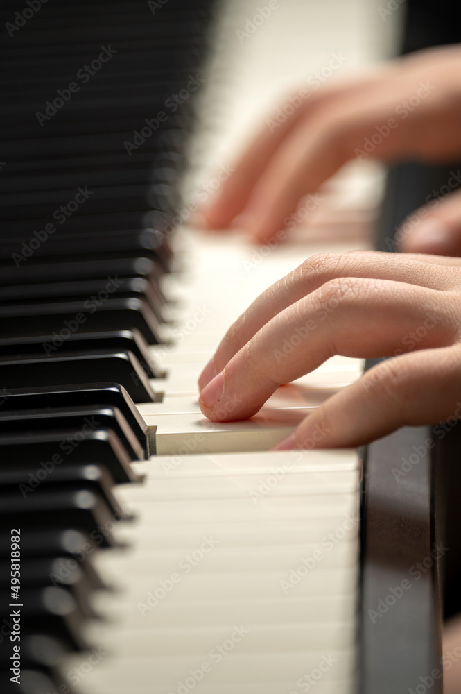 Fototapeta premium Child's hand presses the piano keys