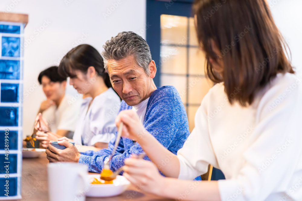 レストランのカウンター席でご飯を食べる人々