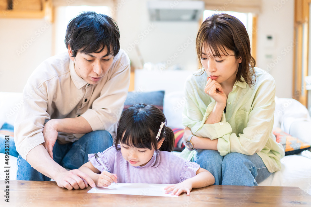 家でお勉強をする女の子と両親