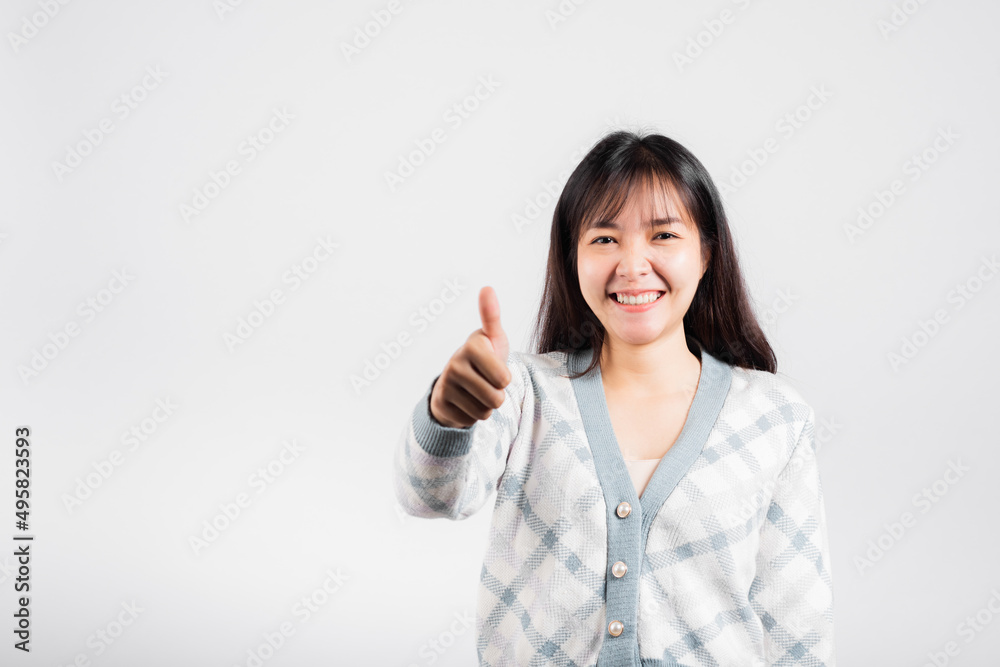 Happy woman smile showing finger thumbs up, Portrait Asian beautiful young female successful like finger gesture, OK sign to agree studio shot isolated on white background with copy space Happy woman smile showing finger thumbs up, Portrait Asian beautiful young female successful like finger gesture, OK sign to agree studio shot isolated on white background with copy space