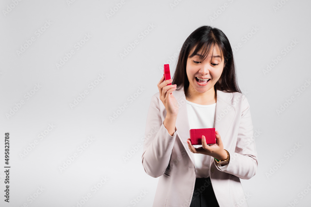 Smiling woman confidence opening a red gift box on palm isolated white background, surprise birthday or Christmas day and valentine, Asian happy portrait beautiful young female studio shot, copy space Smiling woman confidence opening a red gift box on palm isolated white background, surprise birthday or Christmas day and valentine, Asian happy portrait beautiful young female studio shot, copy space