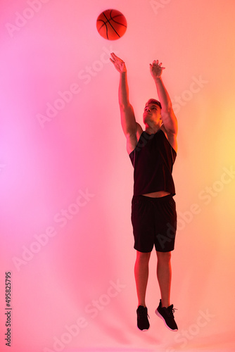 Shoot your shot. Studio shot of a handsome young male basketball player taking a jump shot against a multi-coloured background.