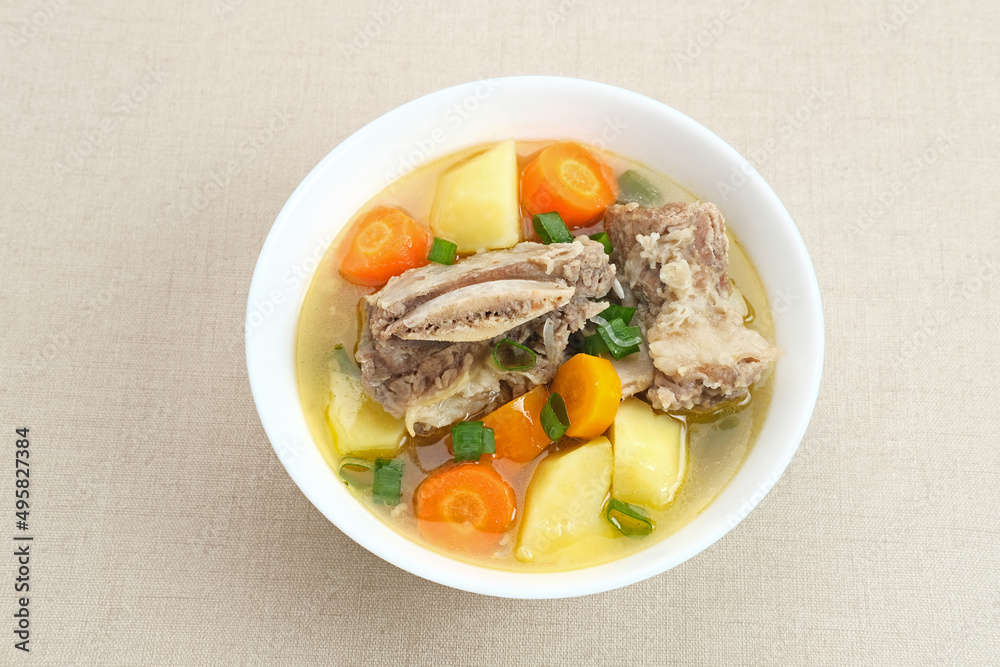 Sop Iga (Beef ribs soup) is Indonesian soup. Made from ribs, carrots, leeks, and potatoes. Served in white bowl. Selected focus
Sop Iga (Beef ribs soup) is Indonesian soup. Made from ribs, carrots, leeks, and potatoes. Served in white bowl. Selected focus