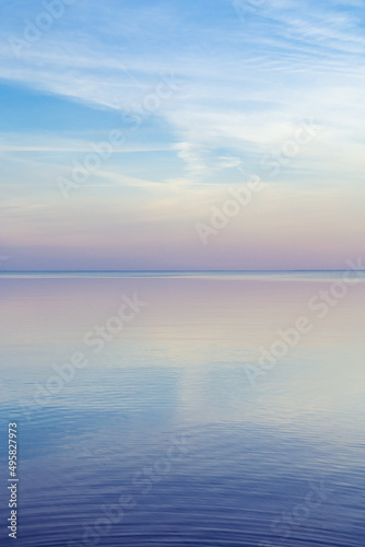 Beautiful sunset on sea, pastel colors and reflections on water, calm nature landscape with colorful clouds