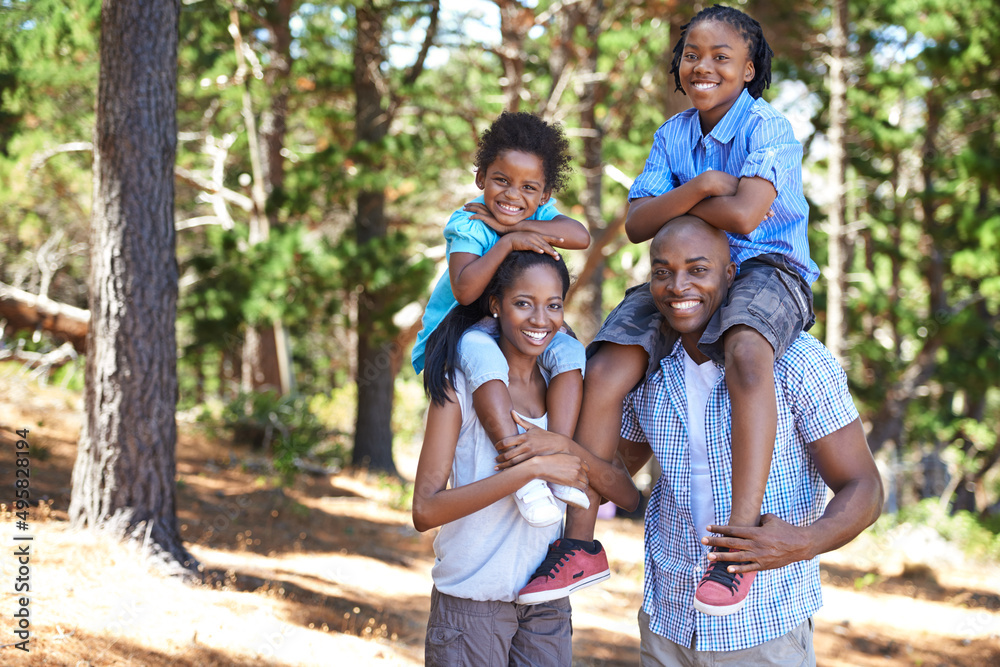 Fototapeta premium Making sure they dont get too tired. Portrait of a mother and father carrying their children on their shoulders while out for a hike.