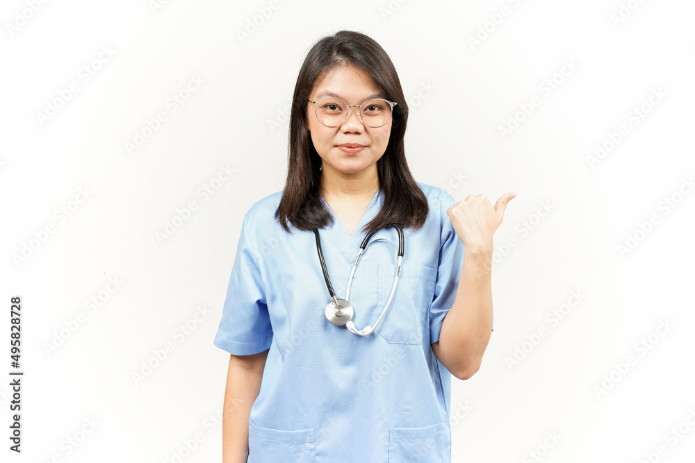 Showing and Pointing Product With Thumb Of Asian Young Doctor Isolated On White Background Showing and Pointing Product With Thumb Of Asian Young Doctor Isolated On White Background