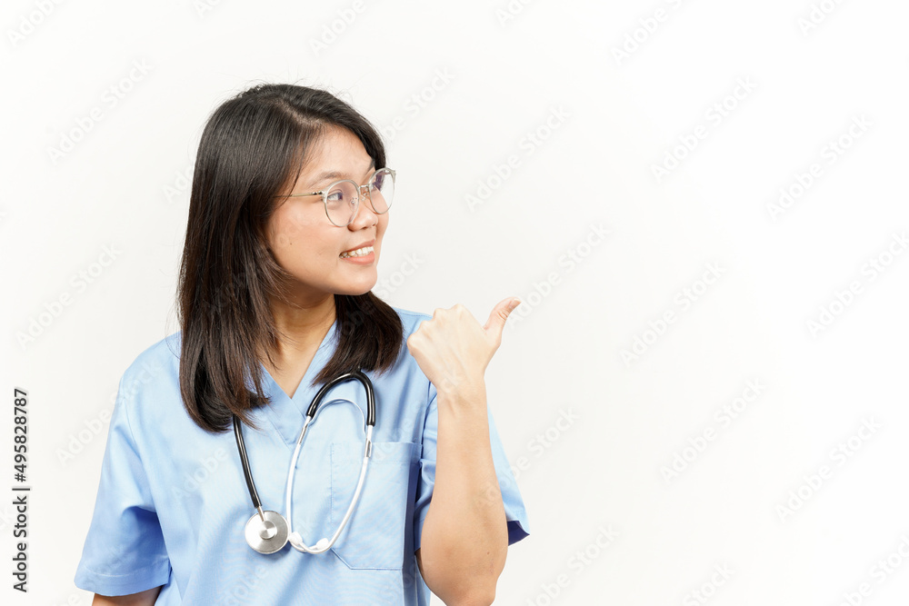 Showing and Pointing Product With Thumb Of Asian Young Doctor Isolated On White Background Showing and Pointing Product With Thumb Of Asian Young Doctor Isolated On White Background