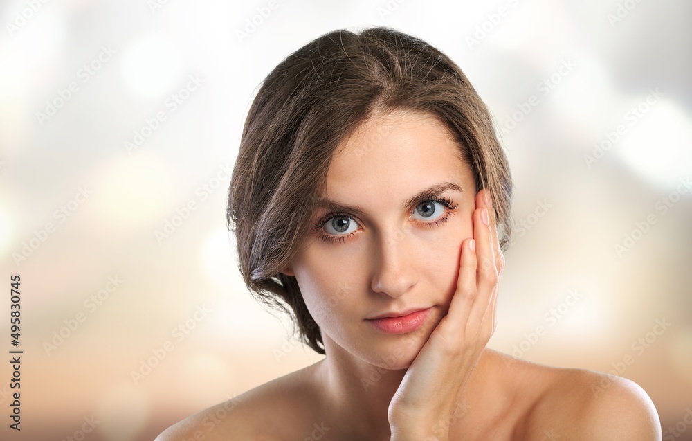 Beautiful young woman with clean fresh skin on blur bokeh background, Face care, Facial treatment, Cosmetology, beauty and spa concept Beautiful young woman with clean fresh skin on blur bokeh background, Face care, Facial treatment, Cosmetology, beauty and spa concept
