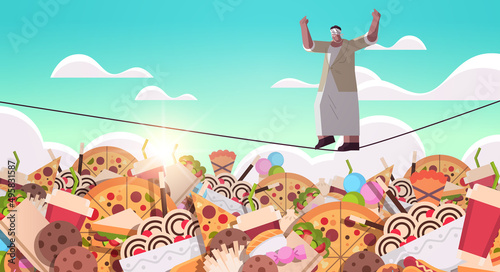 senior woman balancing on rope above junk food assortment of fast food unhealthy nutrition junkfood addiction