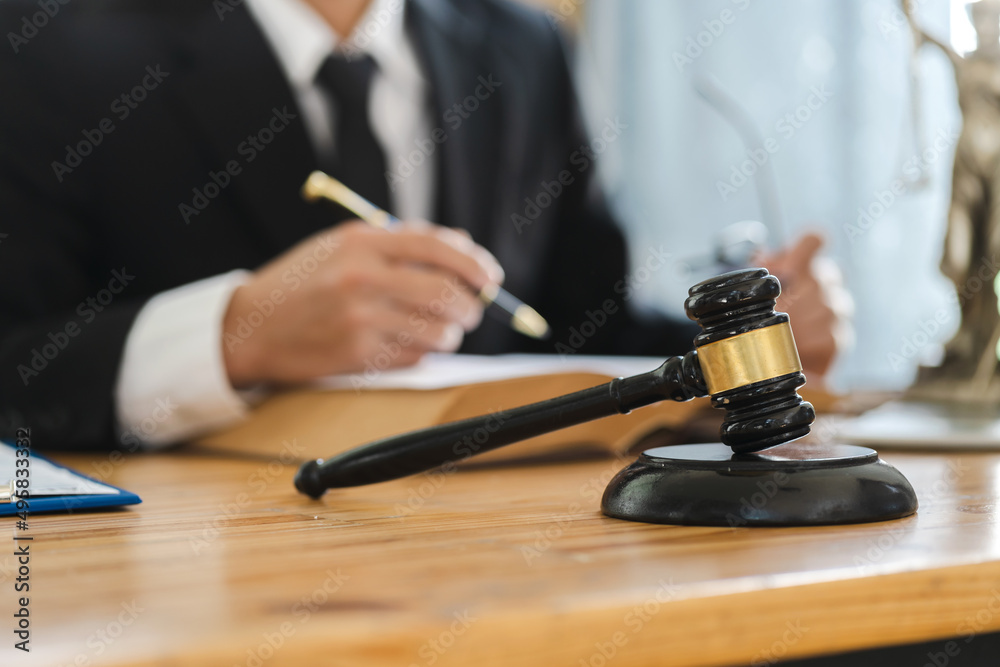 Businessman lawyer working with contract papers and wooden gavel on tabel in courtroom. Businessman lawyer working with contract papers and wooden gavel on tabel in courtroom.