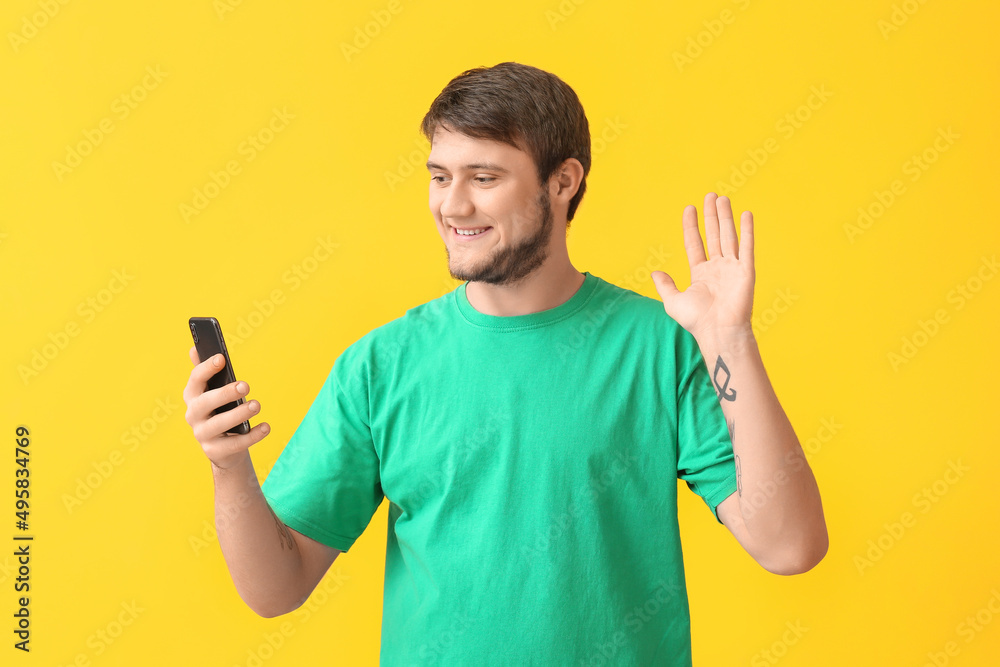 Handsome man with mobile phone video chatting on color background Handsome man with mobile phone video chatting on color background
