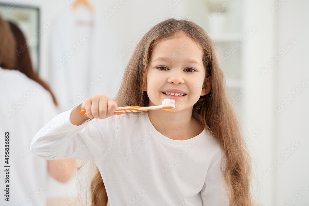 Adorable little girl brushing teeth in bathroom, closeup Adorable little girl brushing teeth in bathroom, closeup